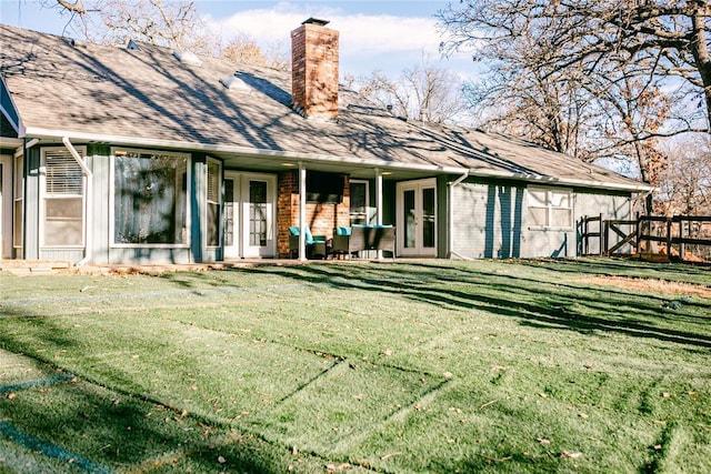 back of house with french doors and a lawn