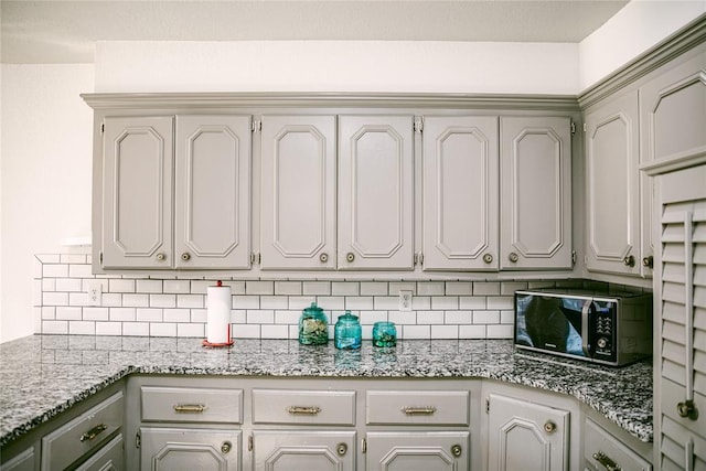 kitchen featuring tasteful backsplash and light stone counters