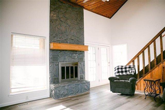 living room featuring wood-type flooring, a fireplace, and high vaulted ceiling