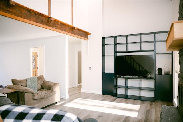 living room with beam ceiling and light wood-type flooring