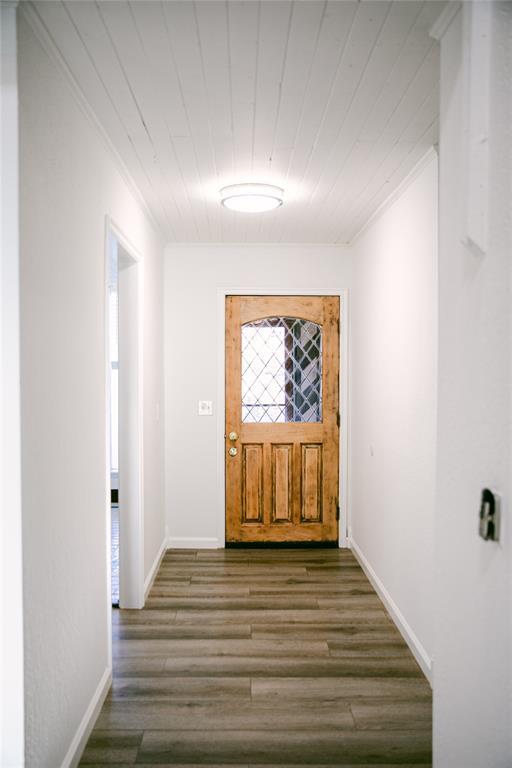 entryway featuring wood-type flooring and ornamental molding