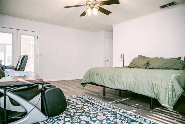 bedroom with french doors, hardwood / wood-style flooring, ceiling fan, and crown molding