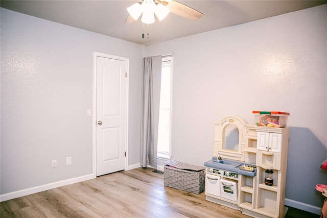 game room with ceiling fan, a healthy amount of sunlight, and light hardwood / wood-style flooring