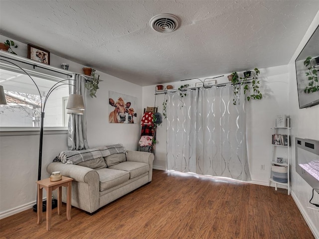 living room with hardwood / wood-style floors and a textured ceiling