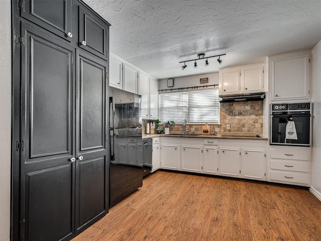 kitchen with light hardwood / wood-style flooring, black appliances, and white cabinets