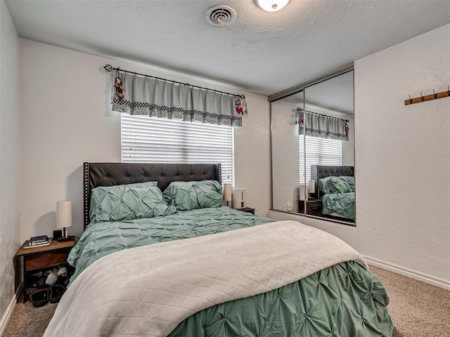 bedroom featuring a textured ceiling and carpet flooring