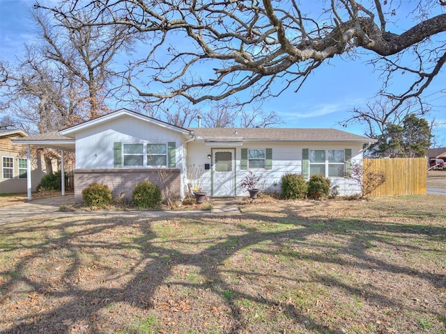 single story home featuring a front lawn and a carport