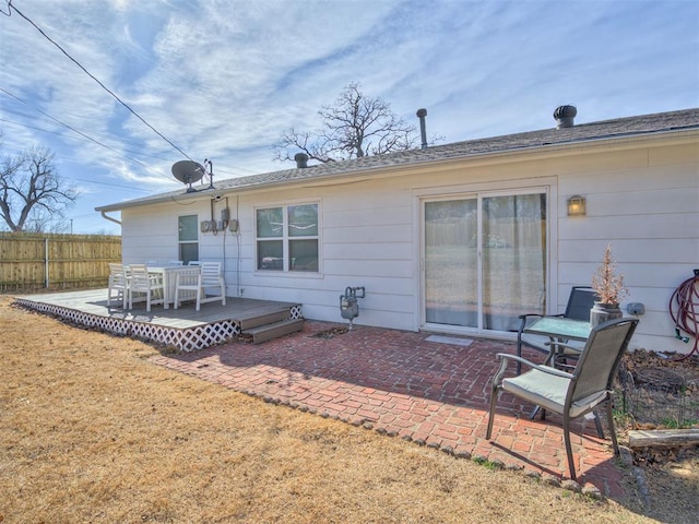 rear view of property featuring a wooden deck, a yard, and a patio area