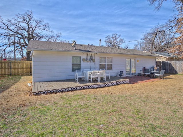 rear view of property with a wooden deck and a yard