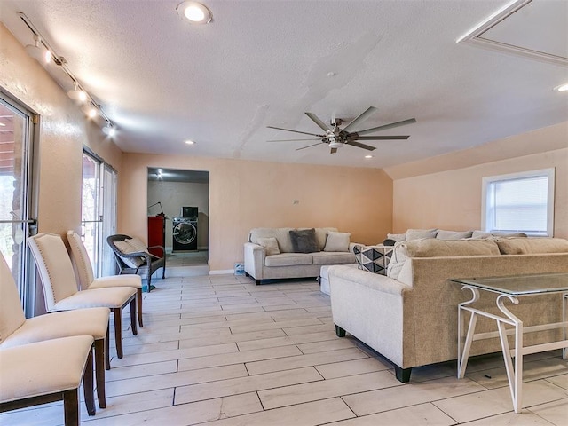 living room with plenty of natural light, ceiling fan, vaulted ceiling, and light hardwood / wood-style flooring