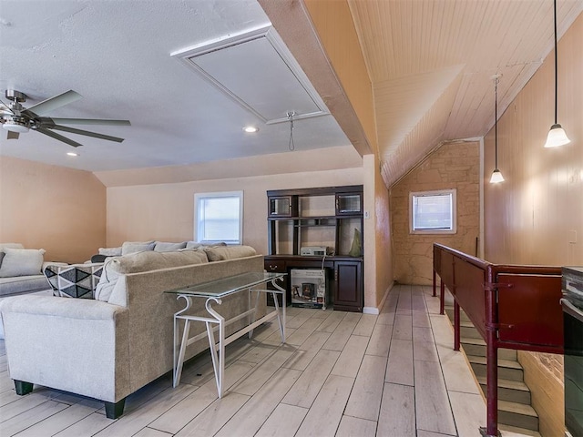 living room with ceiling fan, light hardwood / wood-style floors, and vaulted ceiling