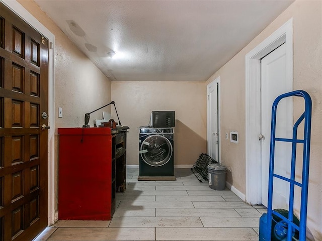 clothes washing area with washer / dryer and light hardwood / wood-style flooring