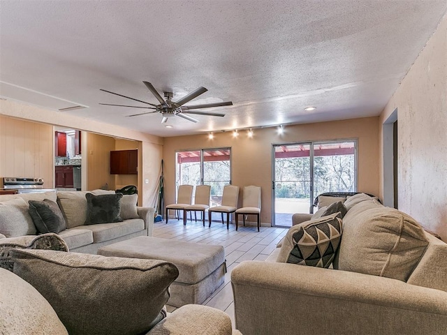 living room with ceiling fan and a textured ceiling