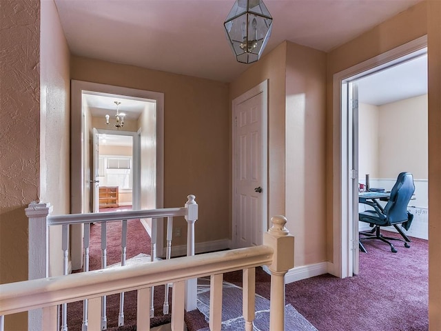 corridor with carpet and an inviting chandelier