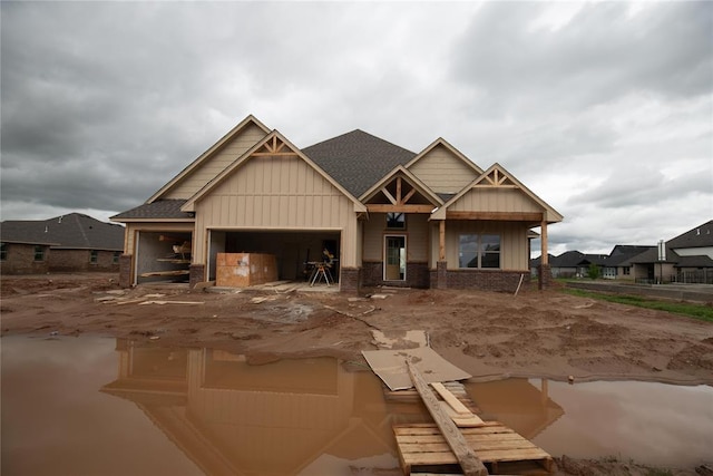 11113 NW 91st St, Yukon, OK 73099 - view of front of house featuring a garage, board and batten siding, a shingled roof, and brick siding
