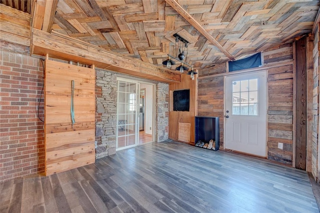 unfurnished living room featuring hardwood / wood-style floors, lofted ceiling, and wood walls