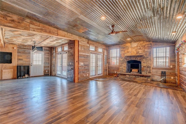 unfurnished living room featuring french doors, wood ceiling, ceiling fan, dark hardwood / wood-style floors, and wood walls