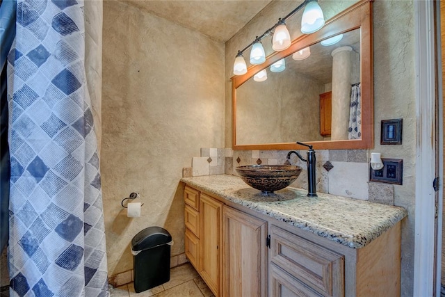 bathroom featuring tile patterned flooring, decorative backsplash, and vanity