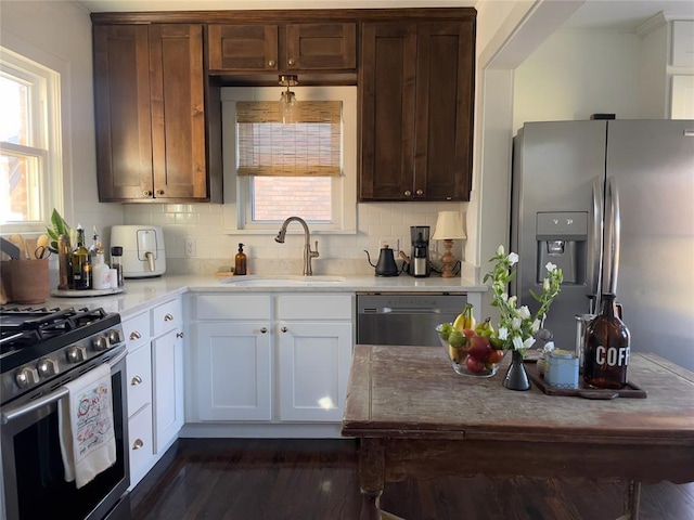 kitchen with white cabinets, appliances with stainless steel finishes, tasteful backsplash, and sink