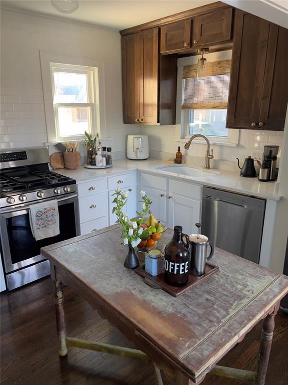 kitchen with sink, stainless steel appliances, dark brown cabinets, and decorative backsplash