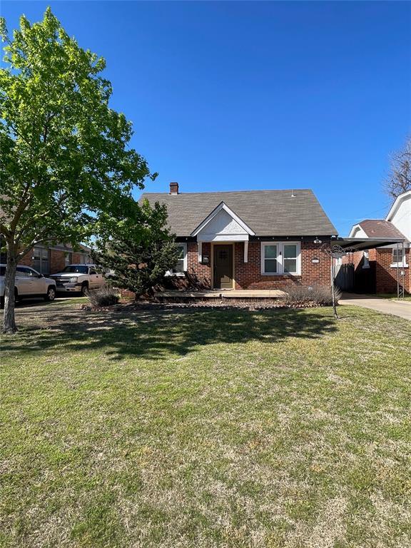 view of front of property with a carport and a front lawn