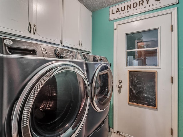 laundry area featuring washing machine and dryer, cabinets, and a textured ceiling