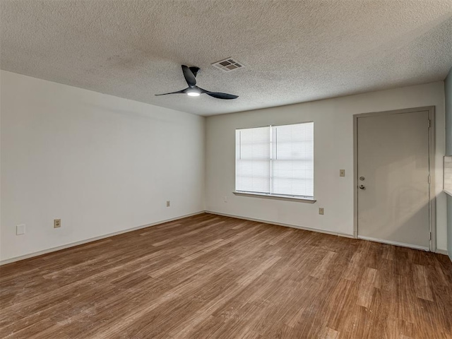 empty room featuring ceiling fan, wood-type flooring, and a textured ceiling