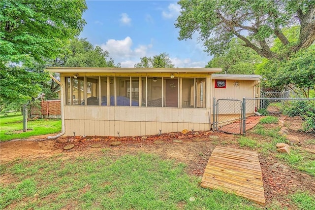 view of home's exterior featuring a sunroom and a yard