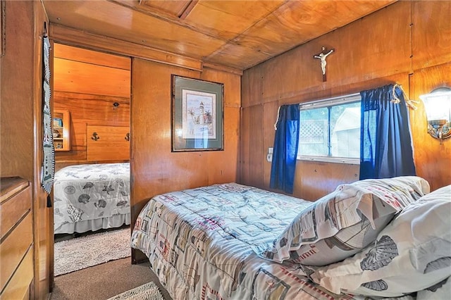 bedroom with wooden walls, dark carpet, and wooden ceiling