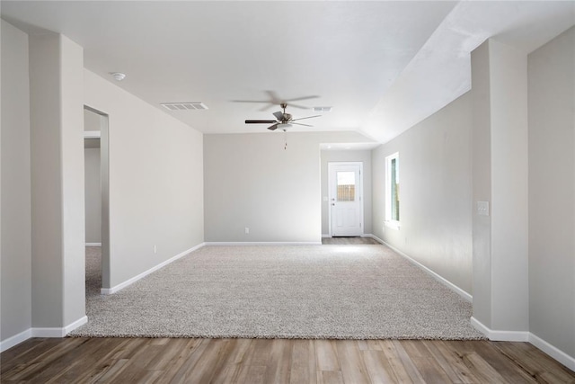 empty room with hardwood / wood-style flooring, ceiling fan, and vaulted ceiling