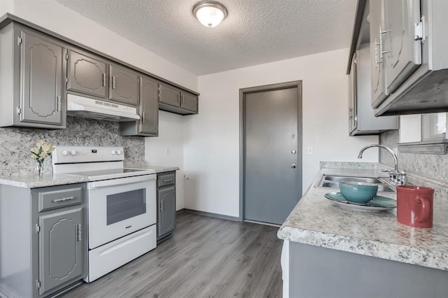 kitchen with white range with electric cooktop, sink, gray cabinets, and a textured ceiling