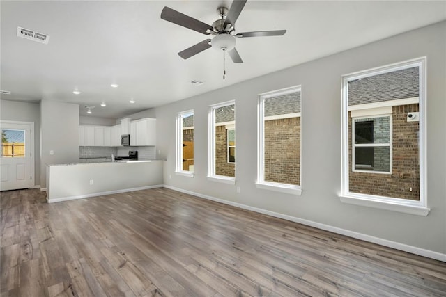 unfurnished living room featuring ceiling fan and light hardwood / wood-style floors