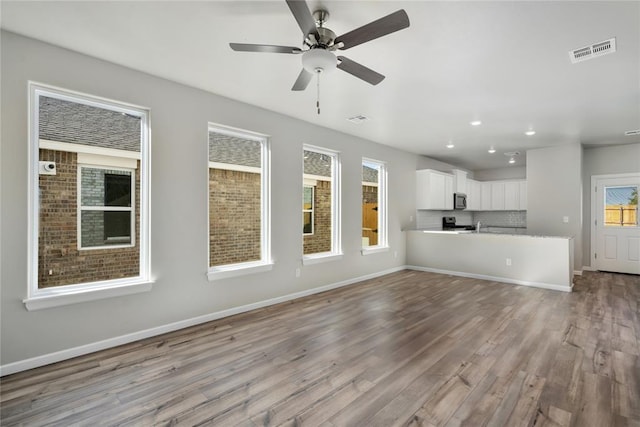 unfurnished living room with light wood-type flooring and ceiling fan