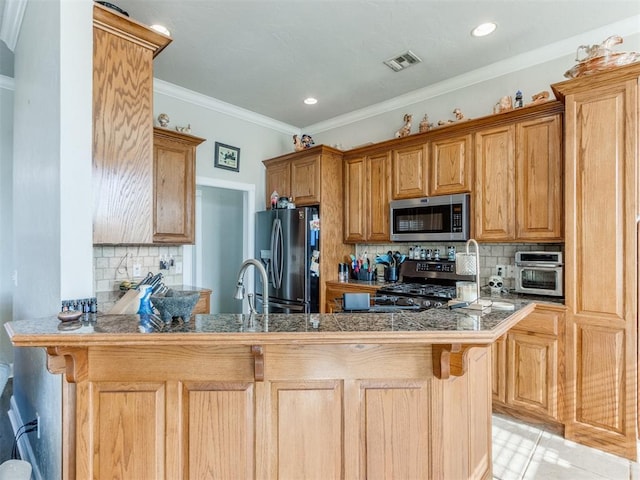 kitchen with decorative backsplash, kitchen peninsula, a breakfast bar area, and appliances with stainless steel finishes