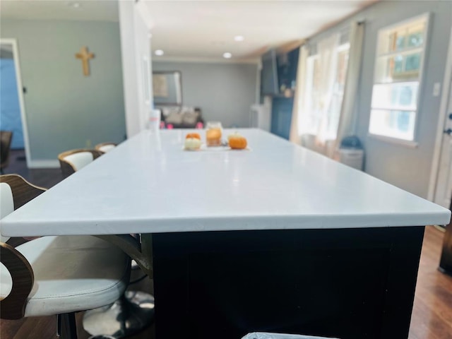 kitchen featuring a center island, wood-type flooring, and a breakfast bar area