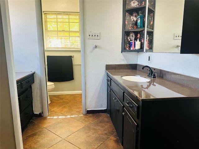 bathroom with tile patterned flooring, vanity, and toilet