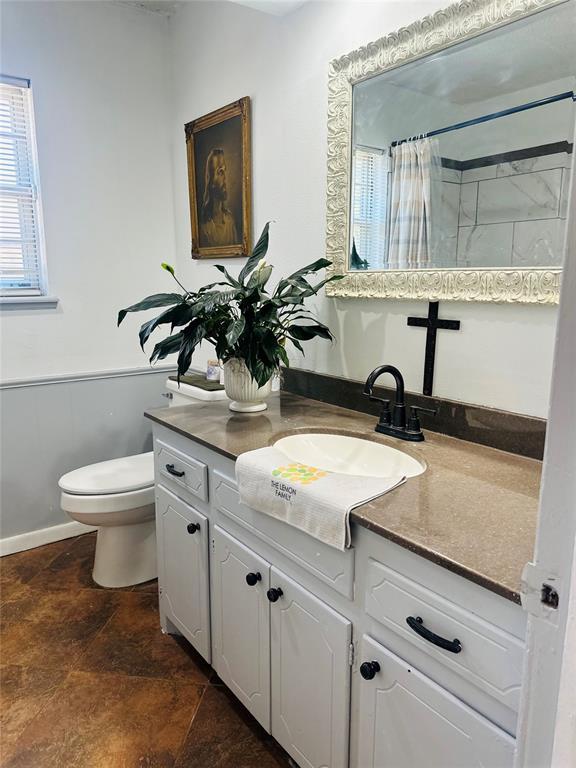 bathroom with a shower with shower curtain, vanity, and toilet