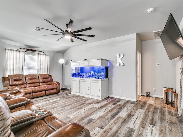 living room with lofted ceiling, ceiling fan, and light wood-type flooring