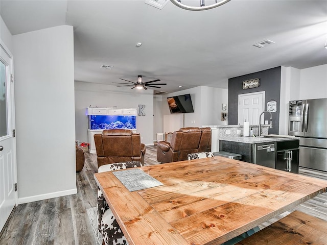 dining space featuring dark hardwood / wood-style floors, ceiling fan, and sink