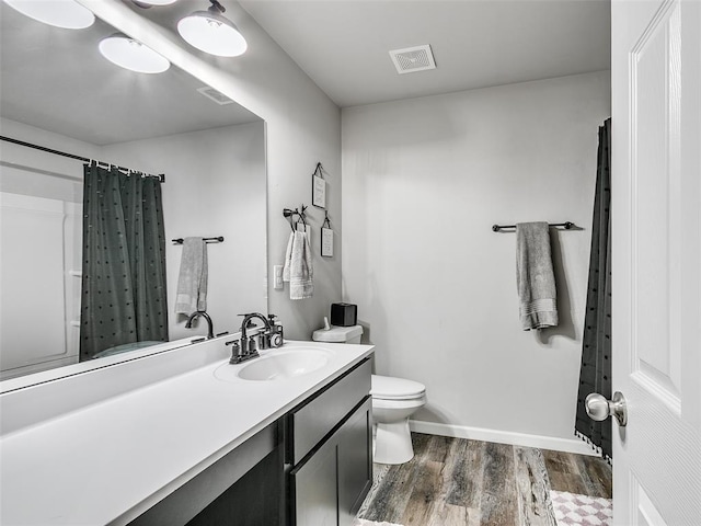 bathroom with hardwood / wood-style flooring, vanity, curtained shower, and toilet