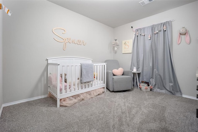 carpeted bedroom featuring a nursery area