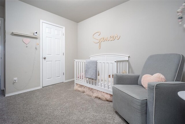 carpeted bedroom featuring a crib