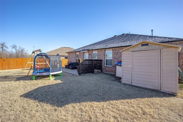 rear view of property featuring a playground, a patio area, and a trampoline