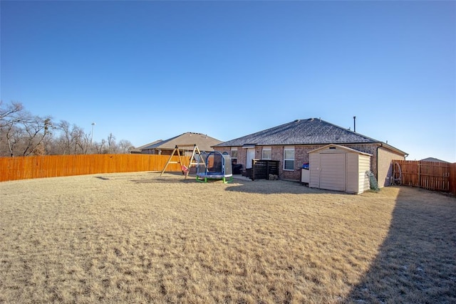 rear view of house with a trampoline and a storage unit