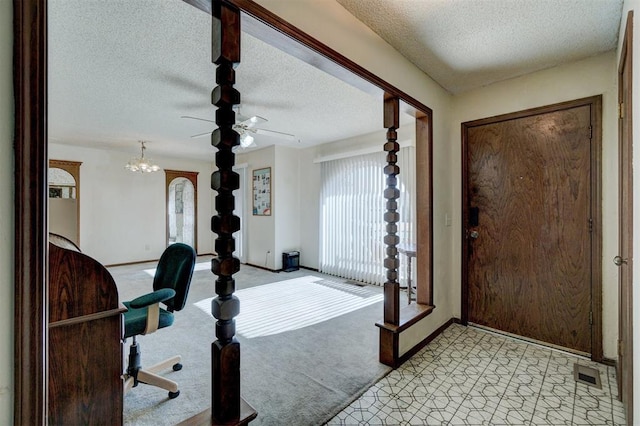 entryway with light colored carpet and a textured ceiling