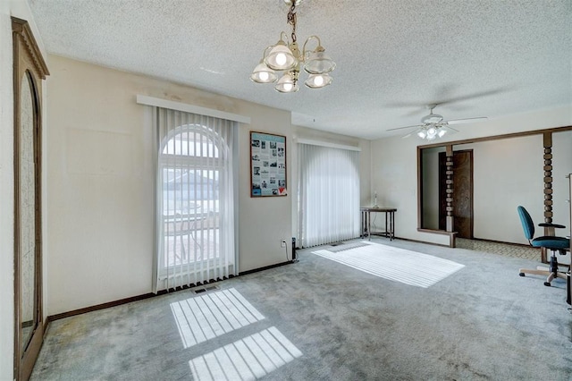 interior space featuring ceiling fan with notable chandelier, light carpet, and a textured ceiling