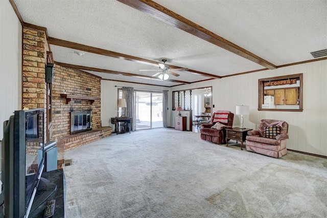 living room with crown molding, a textured ceiling, beamed ceiling, ceiling fan, and carpet