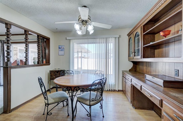 dining room featuring a textured ceiling, ceiling fan, and light hardwood / wood-style flooring