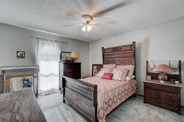 bedroom featuring ceiling fan, light colored carpet, and a textured ceiling