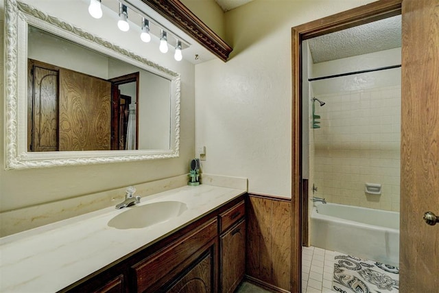 bathroom featuring tiled shower / bath combo, vanity, tile patterned flooring, and a textured ceiling